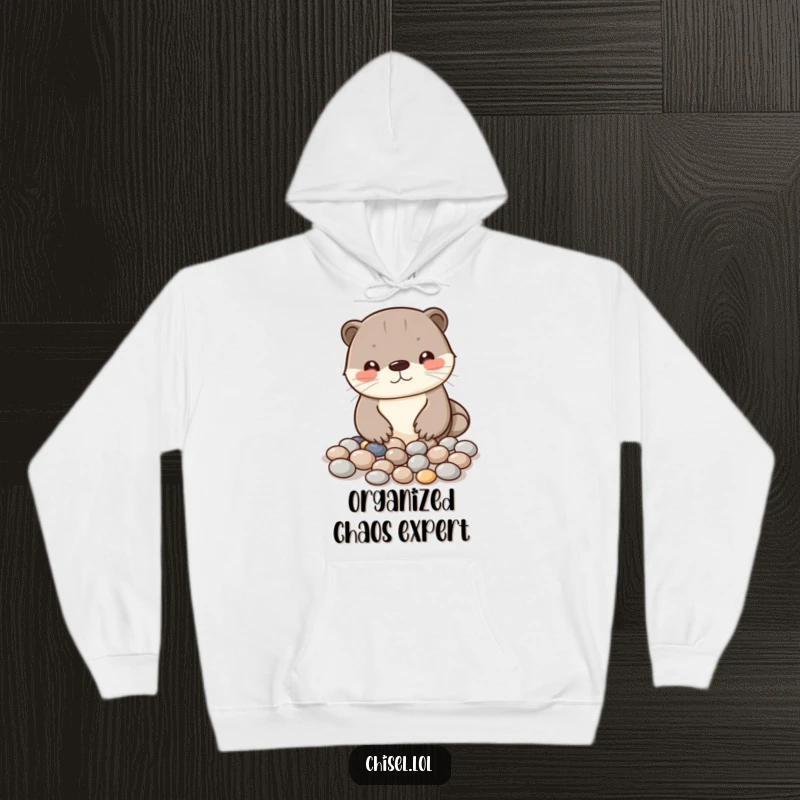 Funny Kawaii otter hoodie showing a curious character arranging shiny pebbles into a pattern, ideal for a humorous present.